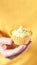 Yellow monochrome bakery. Sustainable cupcake cup. Hold in hand