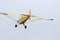 Yellow monomotor airplane low flight