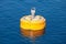 Yellow mooring buoy floating on blue water