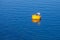 Yellow mooring buoy with hook on blue sea water