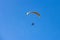 Yellow moto-paraglider flying over clear blue sky