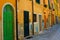 Yellow narrow italian street and green door