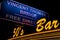Yellow neon sign with the inscription of the bar of the fifties on the background of the road sign Vincent Thomas Bridge free