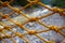 Yellow net on river landscape background. Rustic marine rope net with knots.