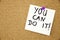 Yellow note paper with inscription you can do it on the white board on cork board background