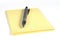 Yellow notepad and silver pen