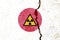 Yellow nuclear warning symbol on the Japan flag on cracked wall background