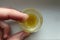 Yellow ointment in a round glass is checked with a finger . Ugly butter and disgusting yellow orange substance on human caucasian
