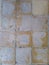 Yellow old-fashioned floor tiles that are fading because they are decades old