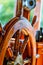 Yellow, old, lacquered, wooden steering wheel on a marine yacht