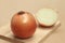 Yellow onion vegetable or gold onion bulb, whole and half on wooden chopping block