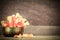 Yellow and orange flowers in grunge brass bowl with heart shaped bokeh on blurred wooden background