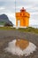 Yellow with orange lighthouse, reflection in the puddle , Iceland