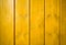 Yellow orange painted wooden wall plank perpendicular to the frame as simple saturated intense yellow color wood background