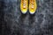 yellow-orange sneakers with untied laces on a dark concrete background. Copy space. Top view