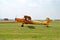 Yellow orange sport airplane after landing on runway on sport airport