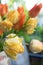 Yellow and orange tulips on the table in a vase. Summer on the balcony