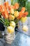Yellow and orange tulips on the table in a vase. Summer on the balcony