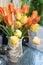 Yellow and orange tulips on the table in a vase. Summer on the balcony