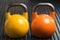 Yellow and orange weight lifting kettlebells inside a gym