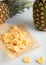 Yellow organic dried sweet pineapple slices on baking paper on light table