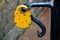 Yellow padlock on black metallic gate