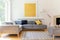 Yellow painting and lamp in modern living room interior with grey corner sofa. Real photo