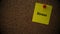 A yellow paper note with the word Stress on it pinned to a cork board