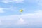Yellow parachute in the blue sky over the sea on the island of Corfu, Greece. Parasailing extreme sports on the beach