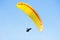 Yellow paraglider in blue sky