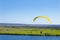 Yellow Paraglider in blue sky above the river and riverside. Bird`s eye panorama. Tom river. Tomsk city, Russia