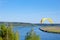 Yellow Paraglider in blue sky above the river and riverside. Bird`s eye panorama. Tom river. Tomsk city, Russia