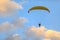Yellow paraglider with a motor at sunset on a background of clouds view from the back