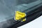 Yellow parking enforcement ticket stuck to car windscreen