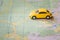 Yellow passenger car travels on a map. The car goes on the route laid by the navigator. Concept vacation and travel