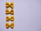 Yellow Pasta, Loop Noodles, Italian Pasta, four Farfalle.  Closeup, in a row, one below the other, in front of white background