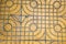 Yellow patterned paving tiles on the street, top view. Cement bricks, squared stone ground floor background texture