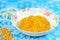 Yellow pease porridge with carrots and onions in a white plate o