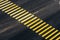 Yellow pedestrian crossing on black asphalt, diagonal