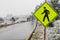 Yellow pedestrian crosswalk crossing street sign in winter snow