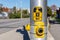 Yellow pedestrian push button on traffic signal pole on the street