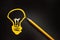 Yellow pencil and hand drawn a light bulb on black background, creative innovation idea symbol concept