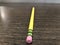 Yellow pencil with pink eraser attached lying on office desk