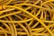 Yellow pile of a tangled long hose or cable wire background texture