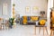 Yellow pillow on grey armchair in spacious flat interior with po