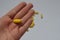 Yellow pills. Homeopathy, treatment, medicine. Pills, capsules in a female palm on a white background.