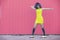 Yellow and pink photo of a teenager woman with afro hair dancing to