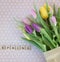 Yellow, pink and purple tulips on white and pink dotted ground with wooden letters sping