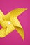 Yellow pinwheel on a fuchsia background