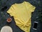 Yellow plain t-shirt mockup coffee cup dark background. Blank cotton shirt template creative design. Female illuminating summer